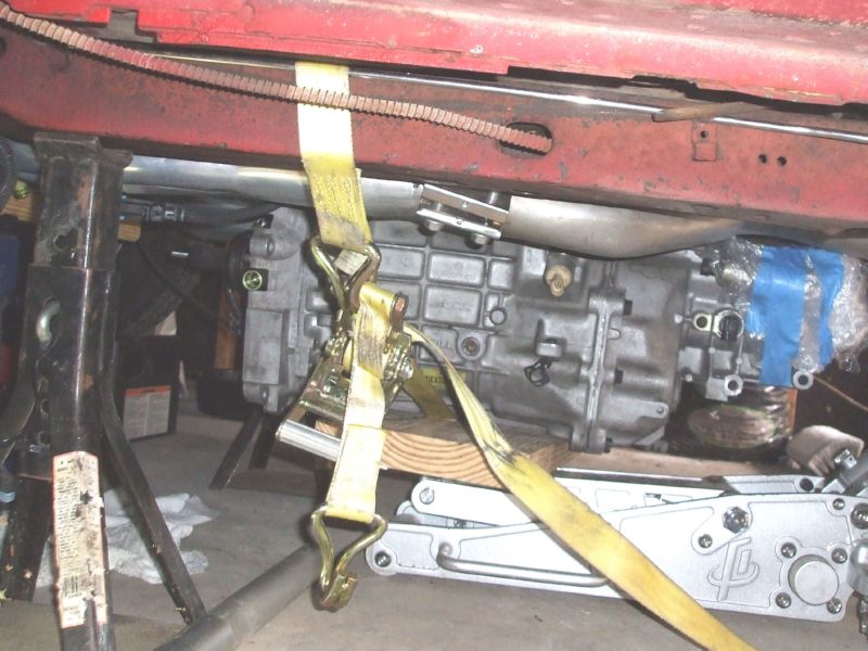 Using a tie down strap to lift the transmission on to the jack